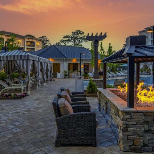 a patio with a fire pit and buildings in the background